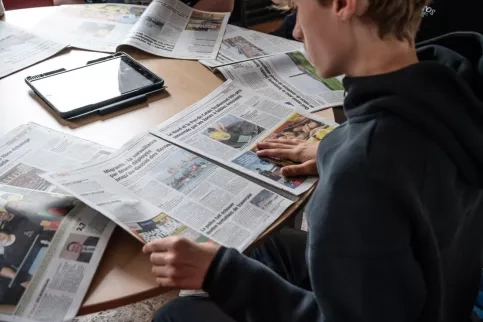 Jeune lisant des journaux