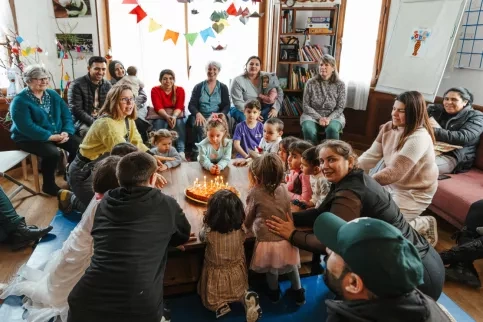 Un groupe d'enfants et d'adultes autour d'un gâteau d'anniversaire