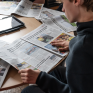 Jeune lisant des journaux